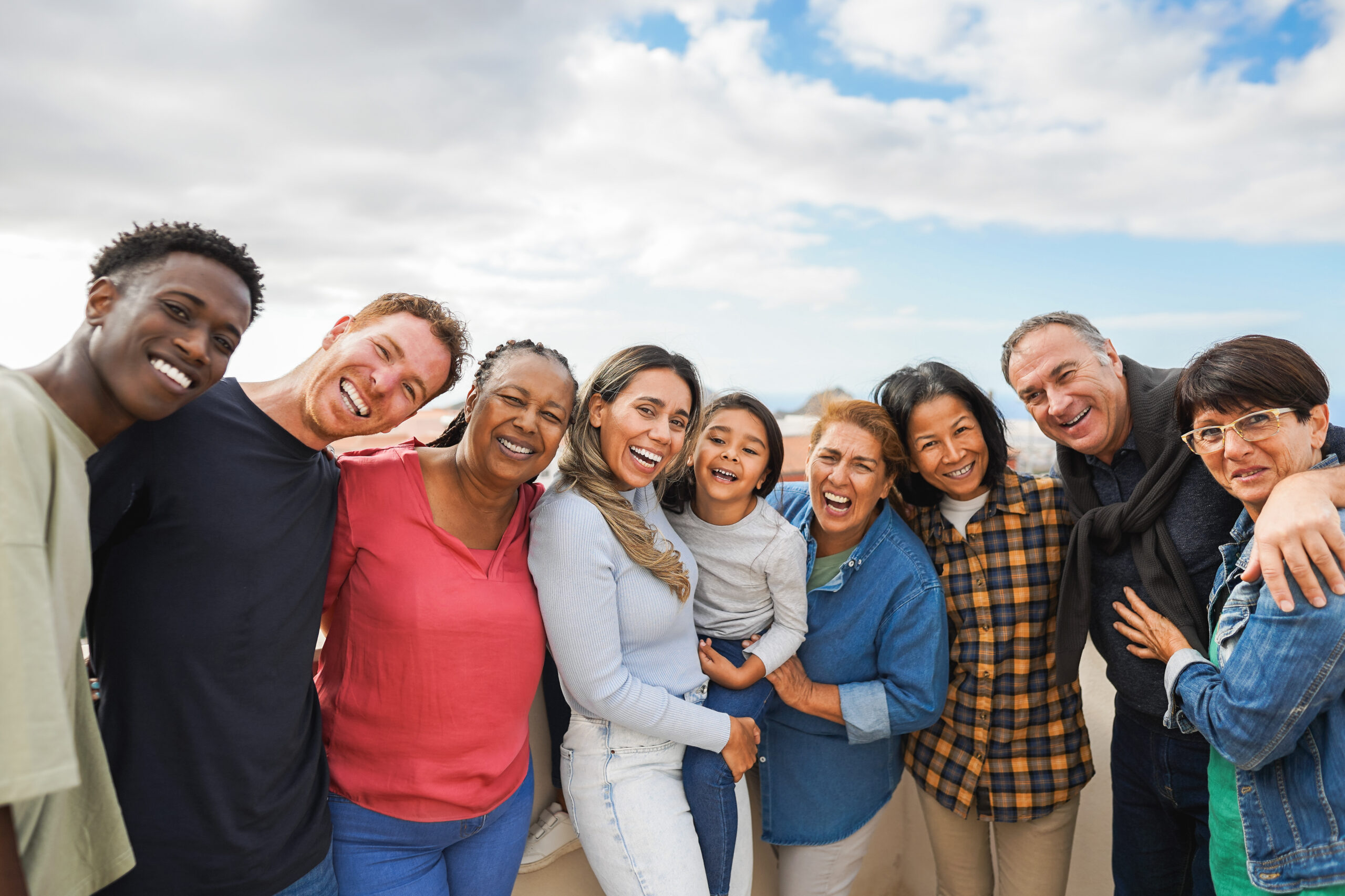 Group of multigenerational friends smiling in front of camera -